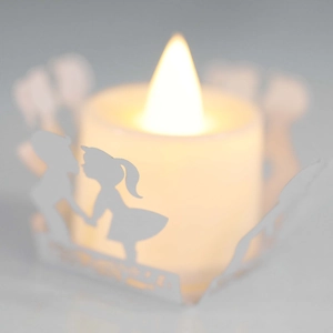 Close-up of LED tea light with laser-cut paper cover featuring a romantic couple silhouette