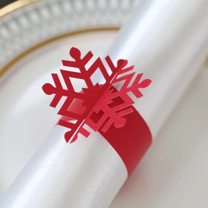 Detailed view of laser-cut red snowflake paper napkin rings for Christmas table settings