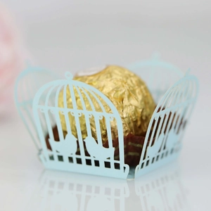 Close-up of laser cut light blue birdcage candy box with intricate silhouette details
