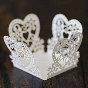 Close-up of laser-cut white heart lace paper favor box for wedding and party candy