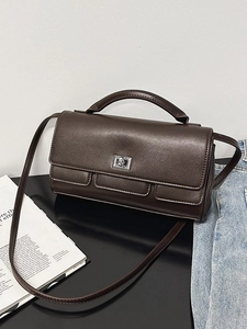 Dark brown leather crossbody bag with silver rotating lock and a stylish top handle