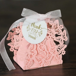 Close-up of pink laser-cut butterfly gift box with thank you tag and organza ribbon