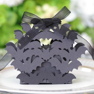 Detail of laser-cut black bat gift box with gold polka dot ribbon for Halloween party