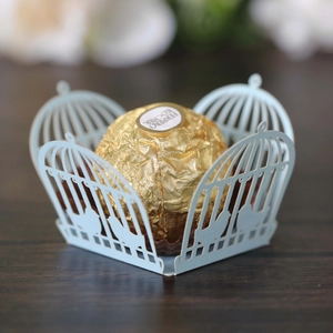 Macro view of light blue laser-cut birdcage candy box with intricate lace patterns