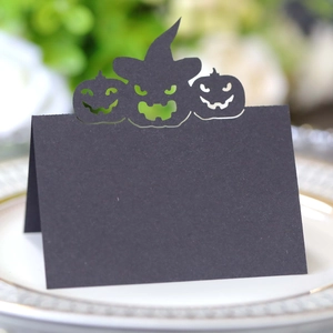 Macro detail of laser-cut black Halloween place card with pumpkin and wizard hat design