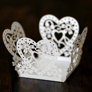 Detailed laser-cut heart and floral lace patterns on white paper wedding favor box
