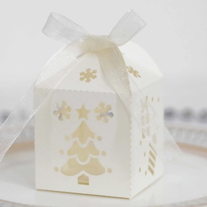 Close-up of white laser-cut Christmas tree candy box with an elegant silk ribbon bow