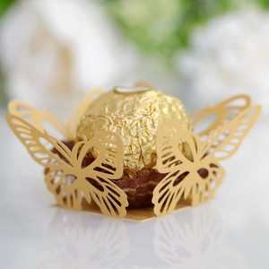 Macro detail of laser-cut gold butterfly decorative holder for wedding chocolates