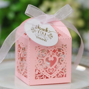Detailed laser-cut heart pattern on pink wedding favor box with thank you tag