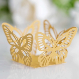 Close-up of laser-cut gold butterfly paper lace for wedding favor and cake decor