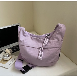Close-up of light purple hobo bag with braided zipper detail and nylon texture on a desk