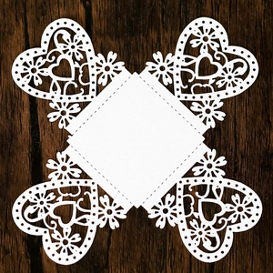 Detail view of laser-cut heart pattern on a white chocolate box on dark wood background