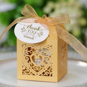 Detailed laser-cut gold wedding favor box with heart patterns and thank you tag