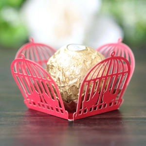 Intricate laser-cut red birdcage chocolate wrapper with festive bird patterns and hollow design