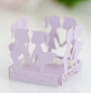 Macro shot of laser-cut lavender paper wrappers with romantic boy and girl silhouettes