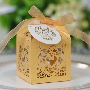 Detailed laser-cut heart hollow design on wedding candy gift box with golden ribbon bow