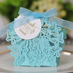 Detail of light blue laser-cut butterfly gift box with ribbon and gold Thank You tag