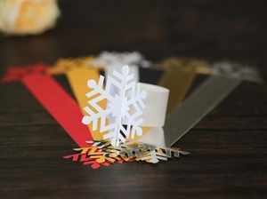 Detail of laser-cut snowflake napkin rings in metallic pearlescent paper colors