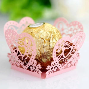 Detail shot of a pink laser-cut hollow heart candy liner with golden chocolate center