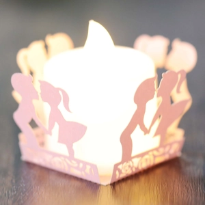 Detail of pink laser-cut paper lantern cover with children silhouette and LED warm light