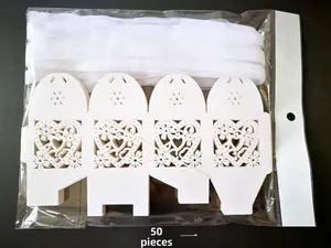 Macro shot of 50 laser-cut heart favor boxes in white cardstock with silk ribbons