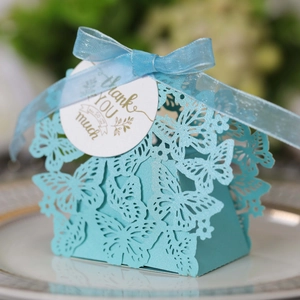 Close-up of light blue laser-cut butterfly gift box with silk ribbon and thank you tag