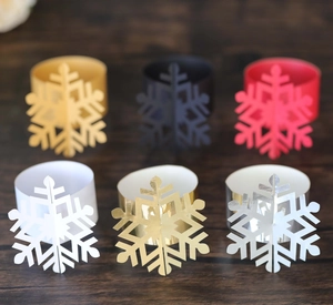 Detailed close-up of six-color snowflake napkin rings arranged on a rustic wooden surface
