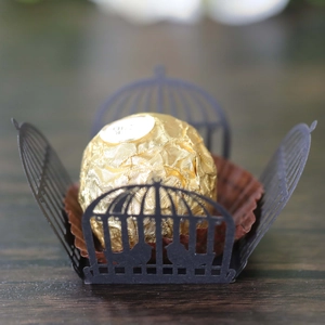 Close-up of black laser-cut birdcage hollow paper chocolate liner for wedding party decor