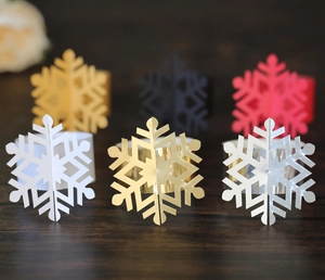 Close-up of laser-cut snowflake napkin rings in gold and silver for Christmas decor