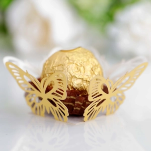 Close-up of laser-cut gold butterfly paper holder for chocolate wedding favors