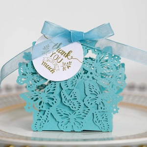 Close-up of laser-cut butterfly gift box with organza ribbon and golden thank you tag