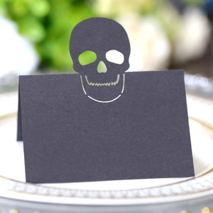 Hollow out black skull place card for Halloween tables on a white decorative tray