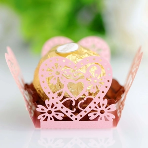 Macro detail of laser-cut pink heart hollow chocolate paper wrap for wedding party favor