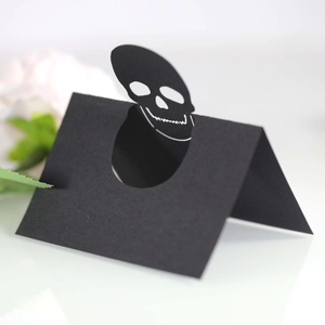 Hollow black skull place cards for Halloween table setting with pop-up 3D design