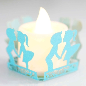 Detail of blue laser-cut paper lantern with couple silhouette and warm LED candle light