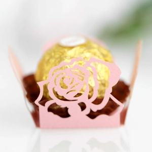 Makroaufnahme von lasergeschnittener Rosen-Papiermanschette in Rosa für Hochzeitsdeko