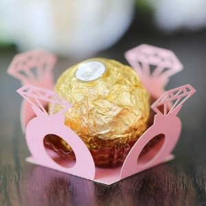 Close-up of laser-cut pink paper diamond ring candy liners for wedding chocolate decor