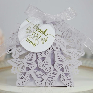 Close-up of laser-cut lavender butterfly favor box with ribbon and thank you tag