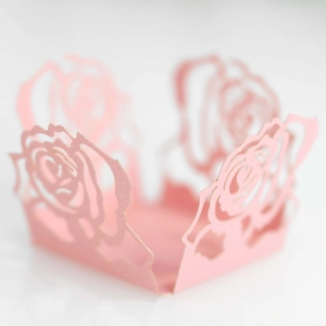 Nahaufnahme rosa lasergeschnittene Papier-Verpackung mit filigranem Rosen-Hohlmuster