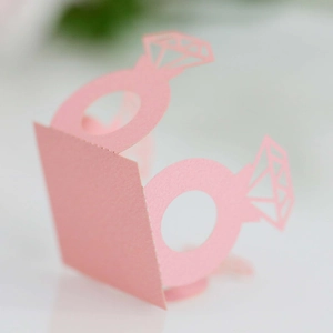 Close-up of laser-cut pink paper diamond ring decoration with hollow detail for weddings
