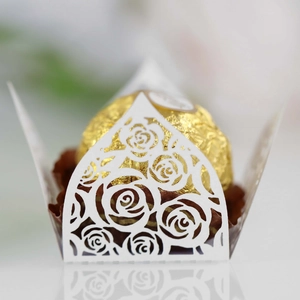 Close-up of laser-cut white rose paper hollow chocolate wrapper with elegant lace details