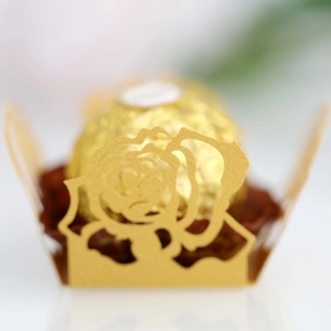 Makroaufnahme goldene lasergeschnittene Pralinenmanschette mit Rosenmuster für Hochzeiten
