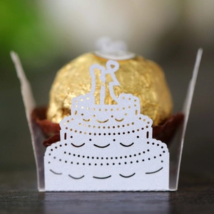 Detailed macro view of laser-cut wedding cake candy box with gold foil chocolate