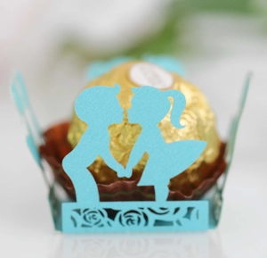 Macro shot of laser-cut blue cardstock chocolate wrap with boy and girl silhouettes