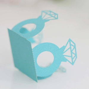 Macro detail of laser-cut light blue diamond ring cardstock decoration for wedding party