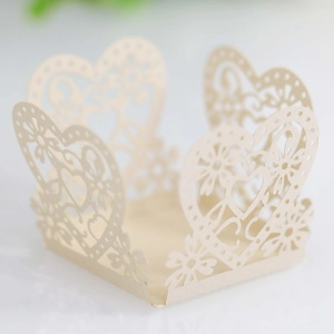 Detail view of laser-cut heart pattern cupcake wrapper in elegant cream pearlescent paper