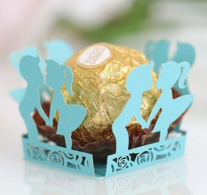 Detail of laser-cut blue paper chocolate wrapper with boy and girl silhouette