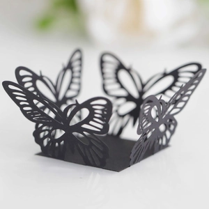 Macro view of black laser-cut butterfly wedding favor box with intricate hollow patterns