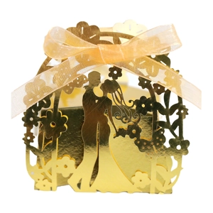 Golden laser-cut wedding favor box featuring bride and groom silhouette with ribbon