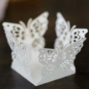 Macro view of white laser-cut butterfly paper decoration for cupcakes and wedding candy boxes